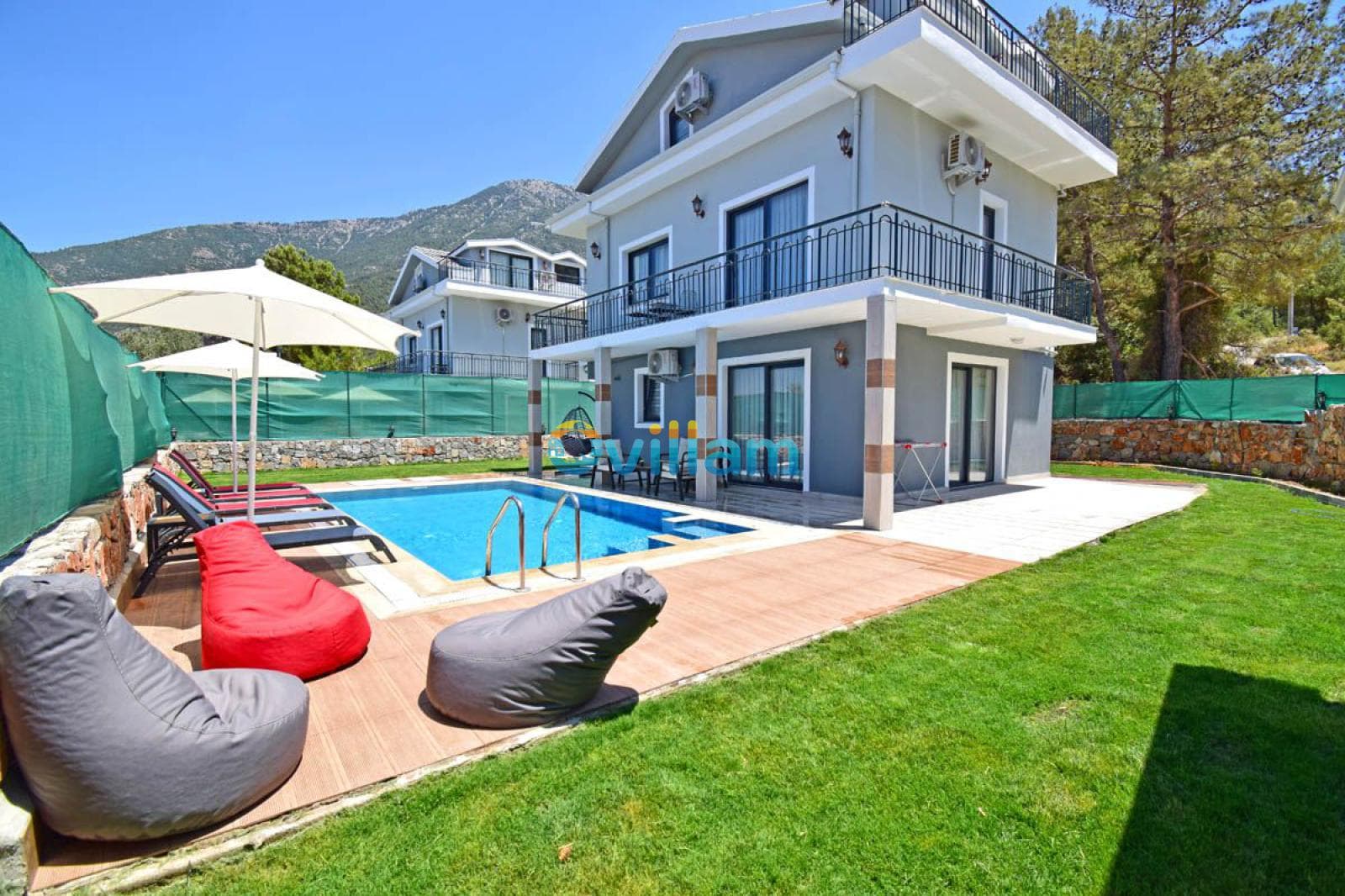 Havuzlu ve bahçeli iki katlı villa dış cephesi.