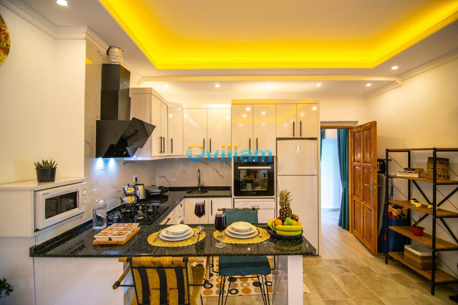 Sarı led aydınlatmalı, siyah tezgahlı ve mutfak gereçlerinin dizili olduğu modern bir mutfak.