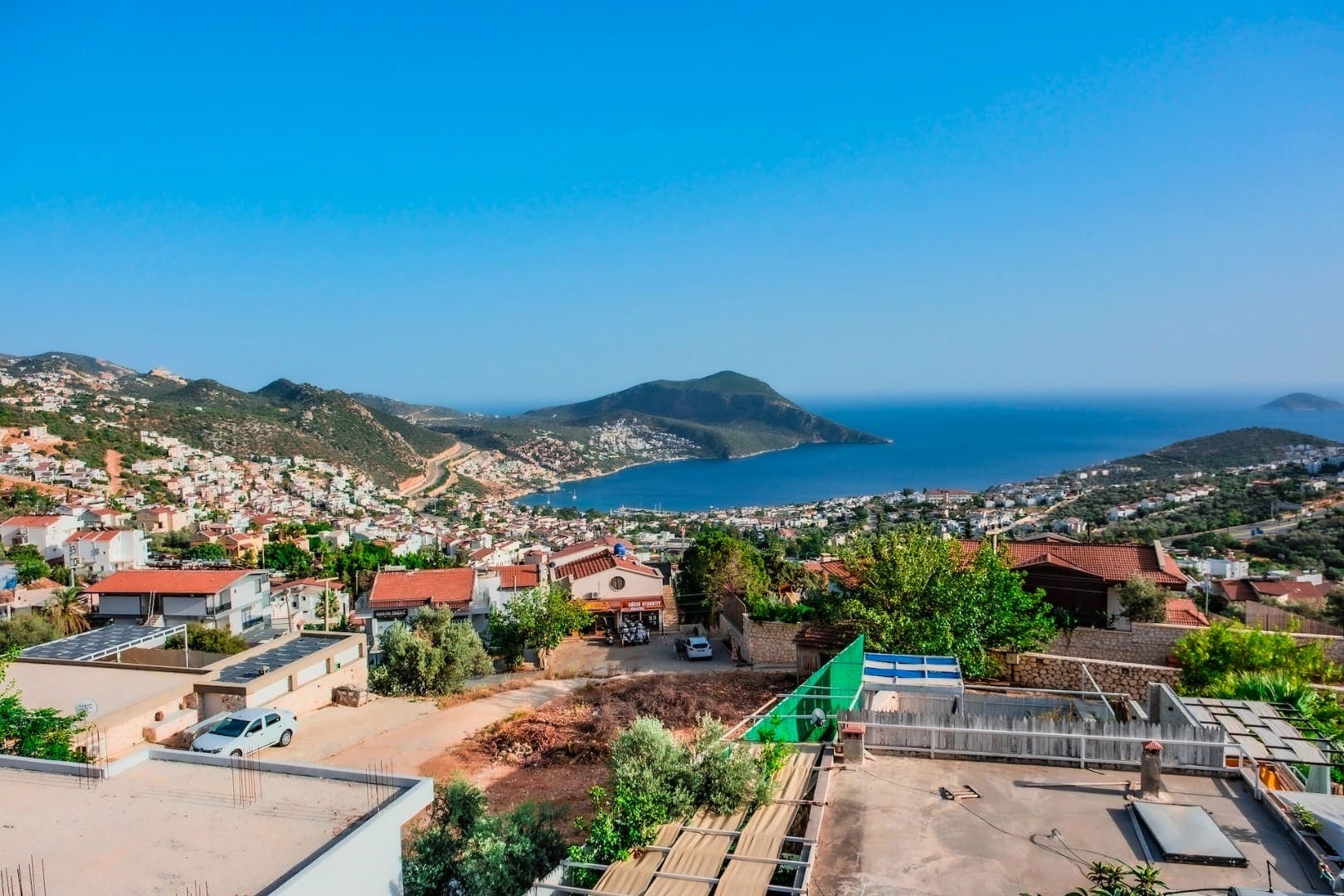 Yüksek bir noktadan görünen deniz, koy ve yerleşim yeri manzarası.
