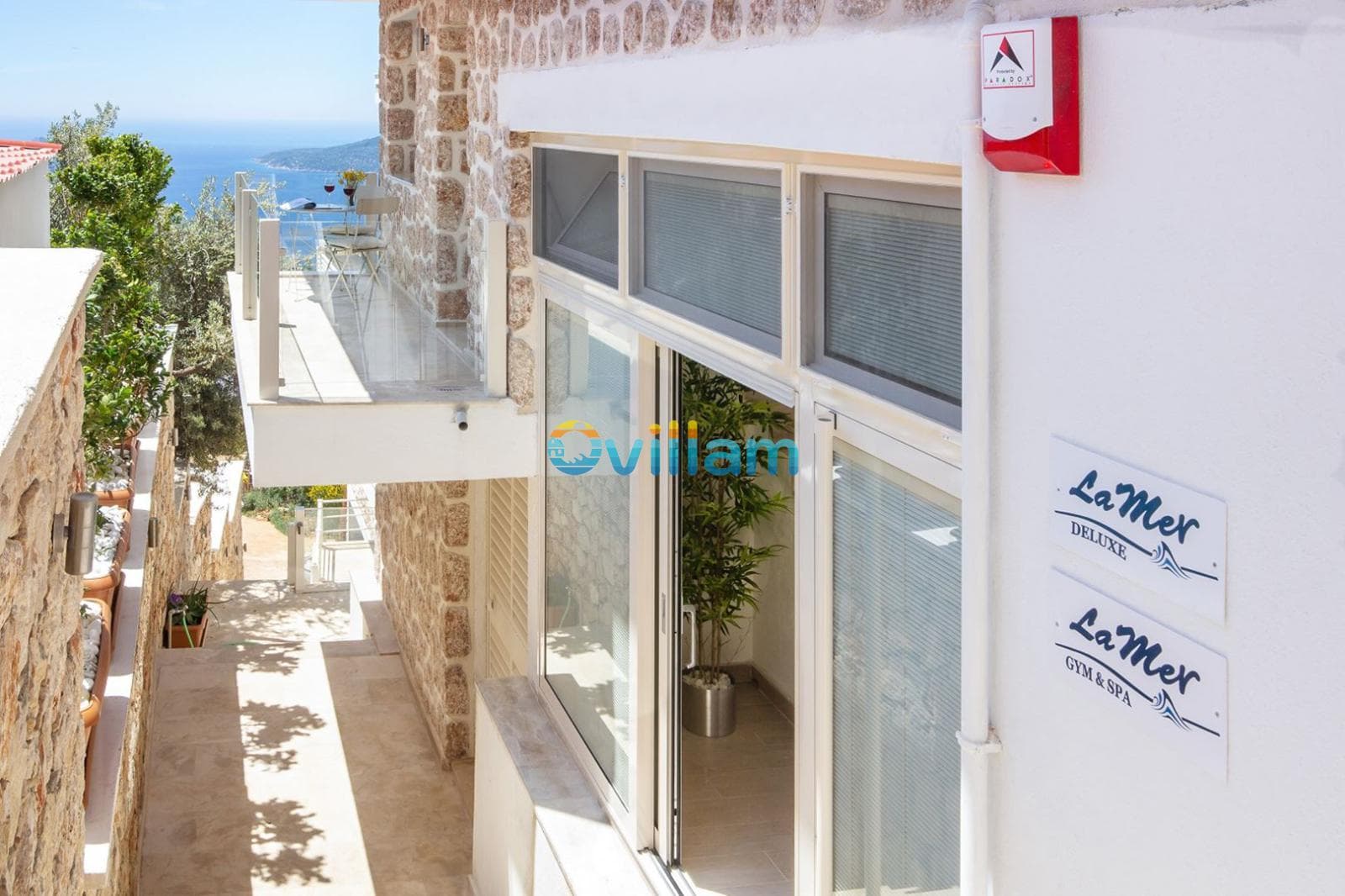 Taş duvarlı dış cephe, balkon ve giriş kapısı.