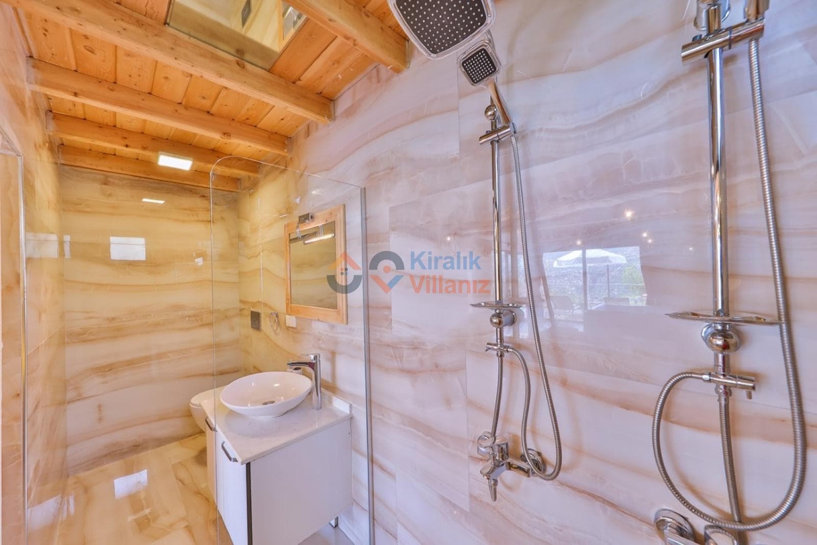 Mermer görünümlü duvarlara sahip duşakabin, krom batarya ve beyaz banyo dolabı.