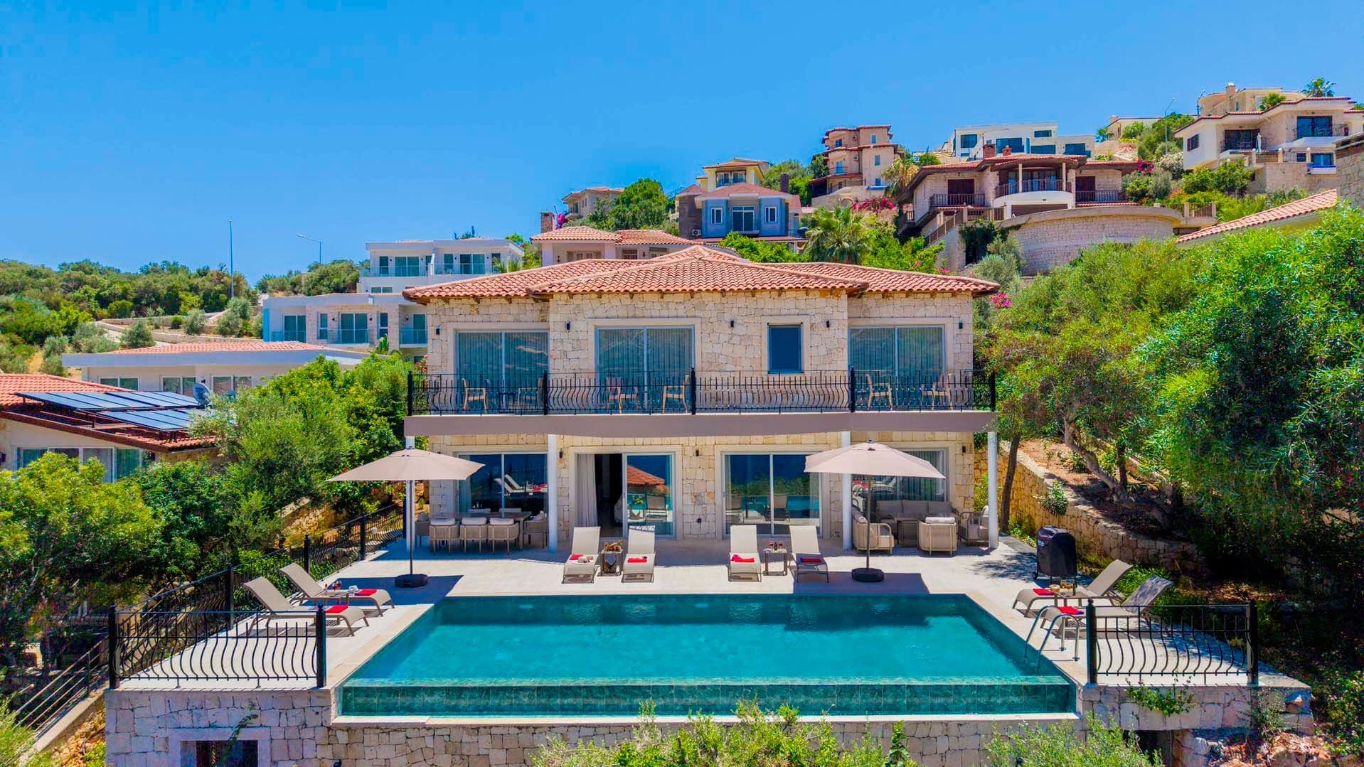 Dağ ve deniz manzaralı villanın havuzlu terası.
