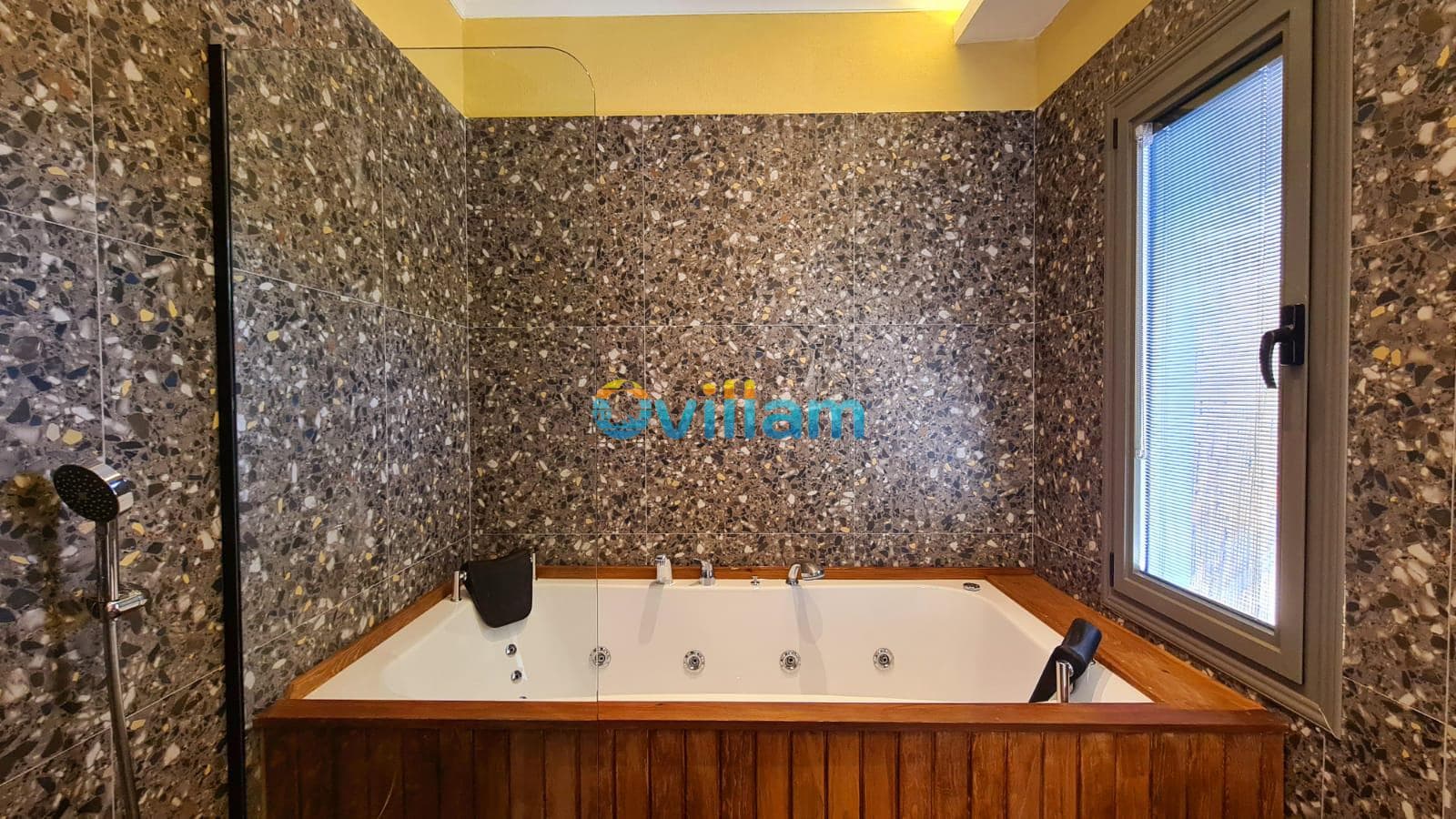 Ahşap kaplamalı jakuzi ve desenli duvar karoları olan banyo.