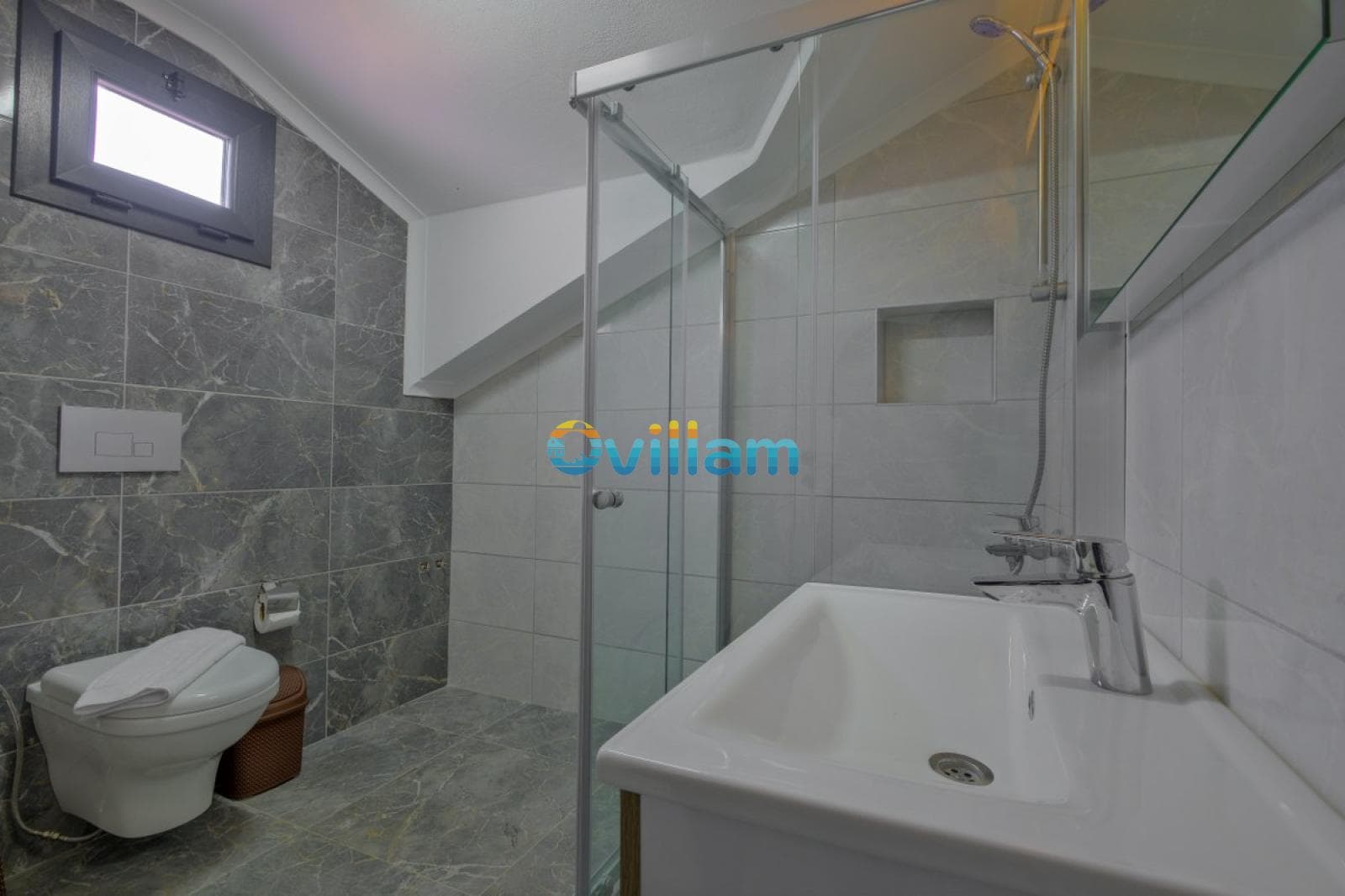 Gri mermer kaplı duvarları olan duşakabinli ve lavabolu banyo.