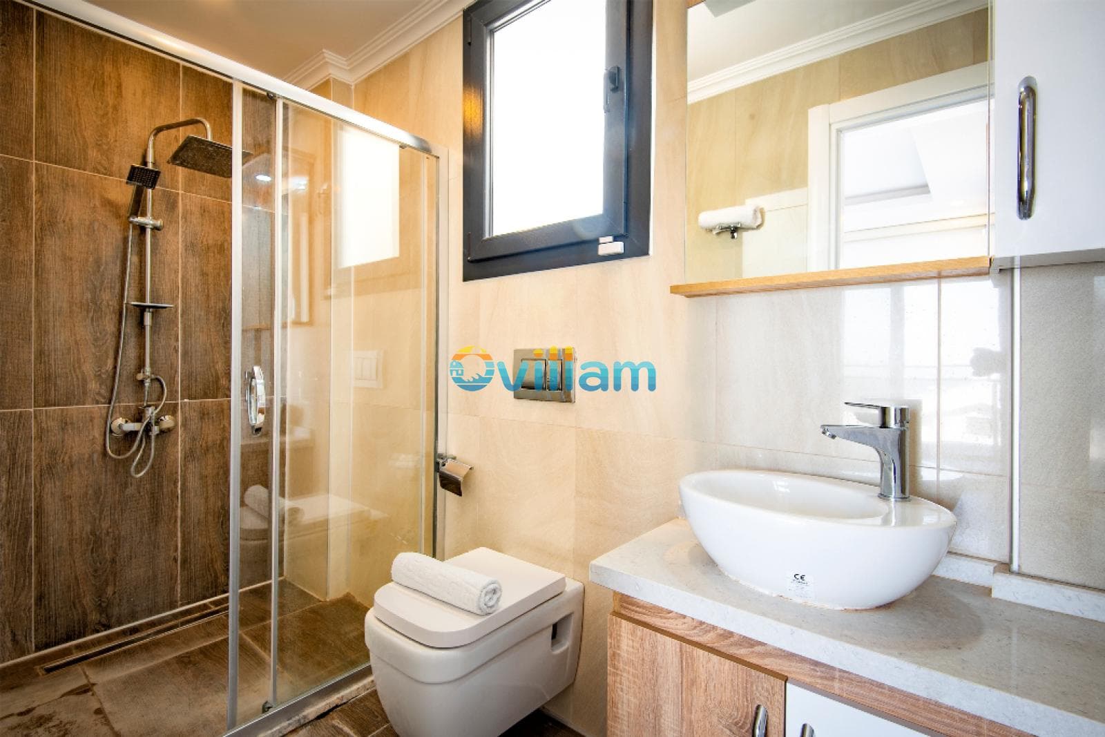Duşakabin, beyaz lavabo ve ahşap görünümlü fayanslarla tasarlanmış modern banyo.