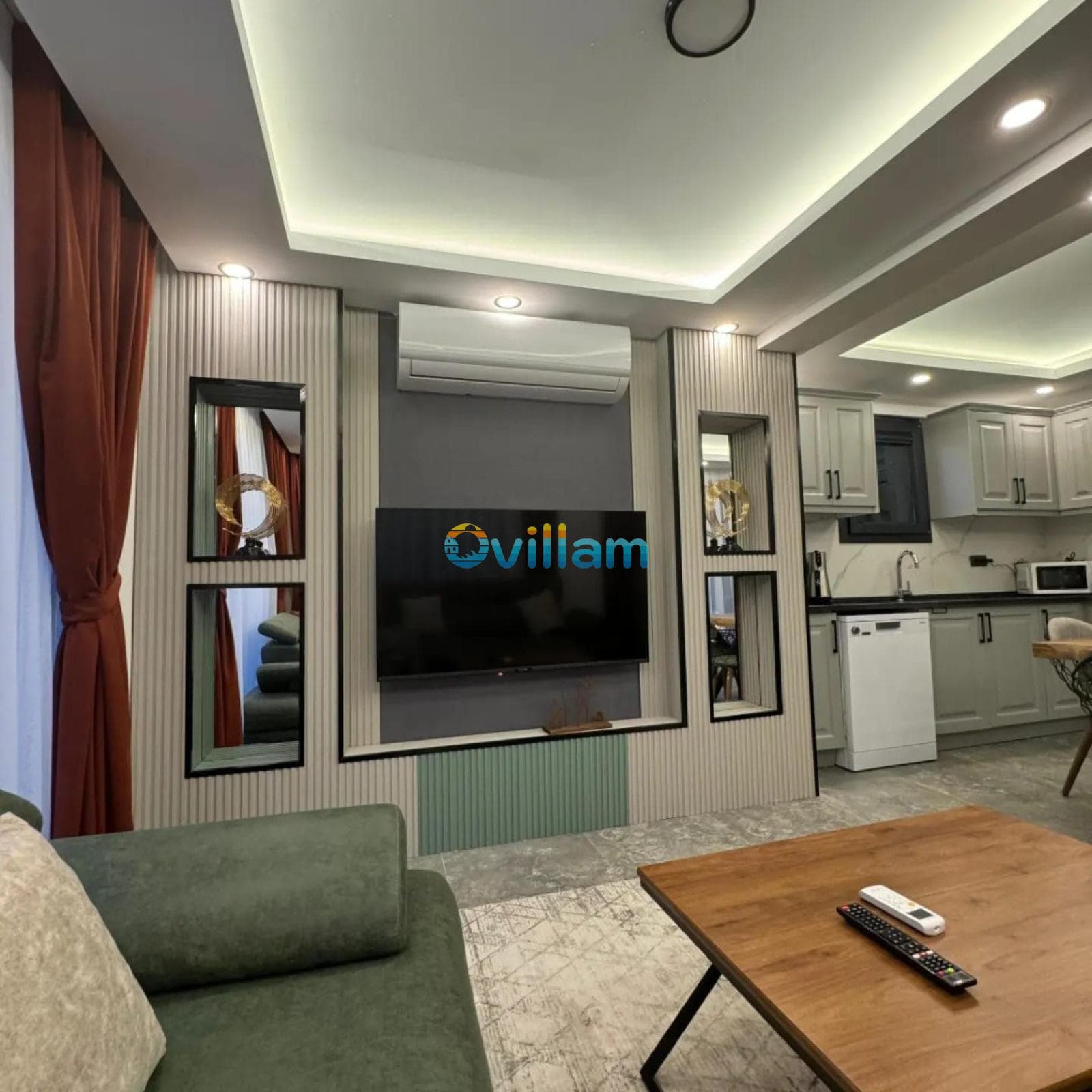 Televizyon ünitesi, klima ve mutfak bölümünün göründüğü modern oturma odası.