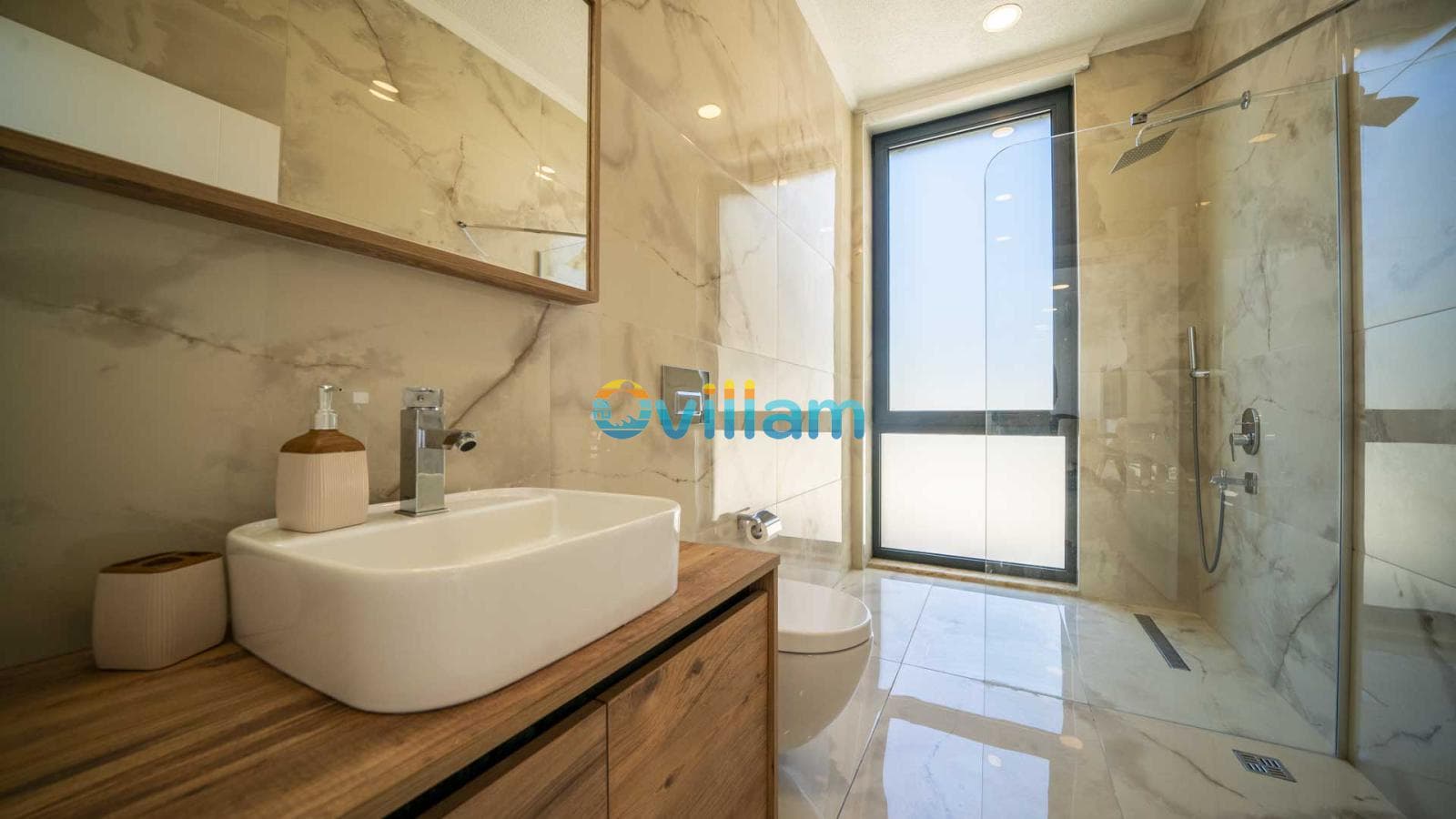 Mermer kaplı modern banyo, duşakabin, lavabo ve geniş bir pencere.