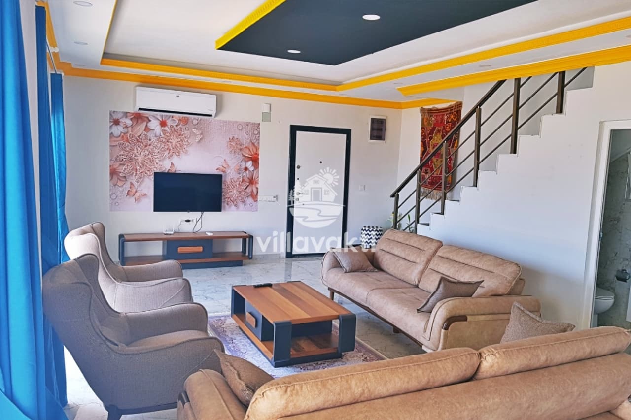 Oturma grubunun, televizyonun ve üst kata çıkan merdivenlerin bulunduğu modern salon.