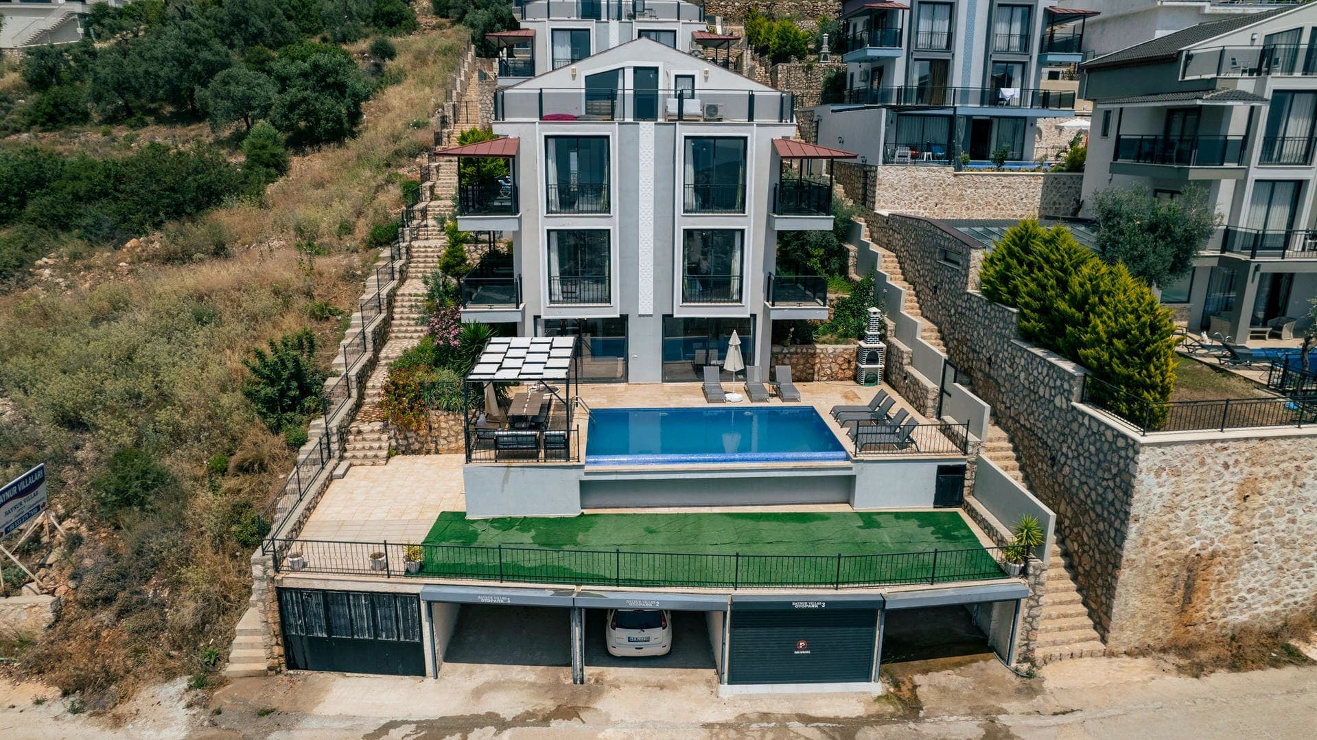 Havuzlu, teraslı ve kapalı otoparkı olan çok katlı modern villa binası.