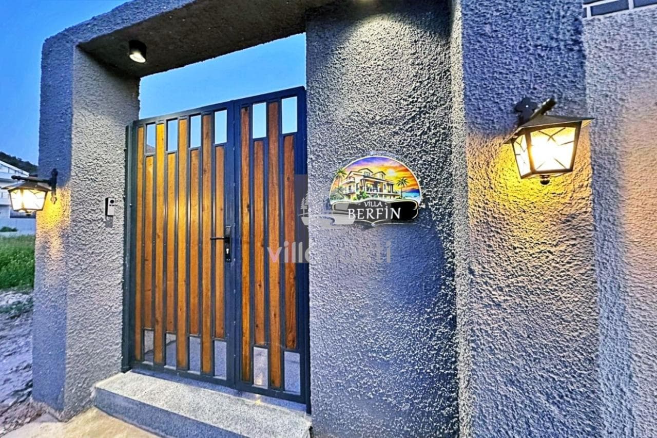 Villa Berfin tabelasının asılı olduğu gri duvarlı giriş kapısı.