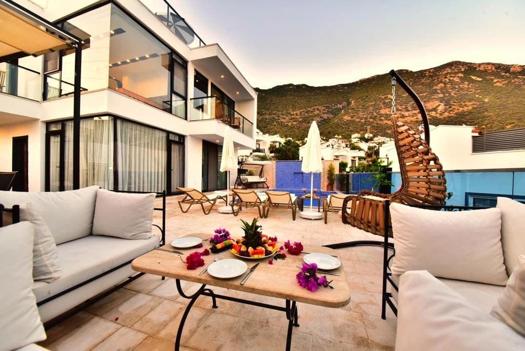 Terası ve havuzu olan modern villanın dağ manzarası.