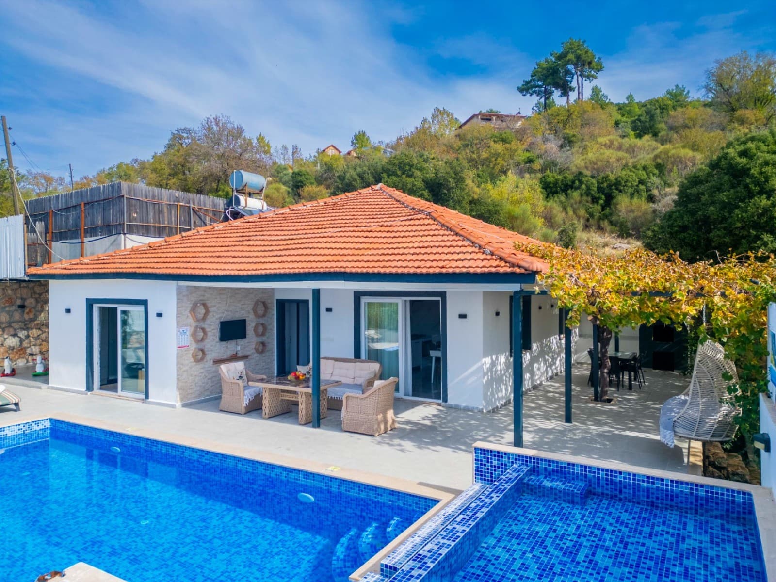 Havuz başında oturma grubu bulunan tek katlı beyaz villa.
