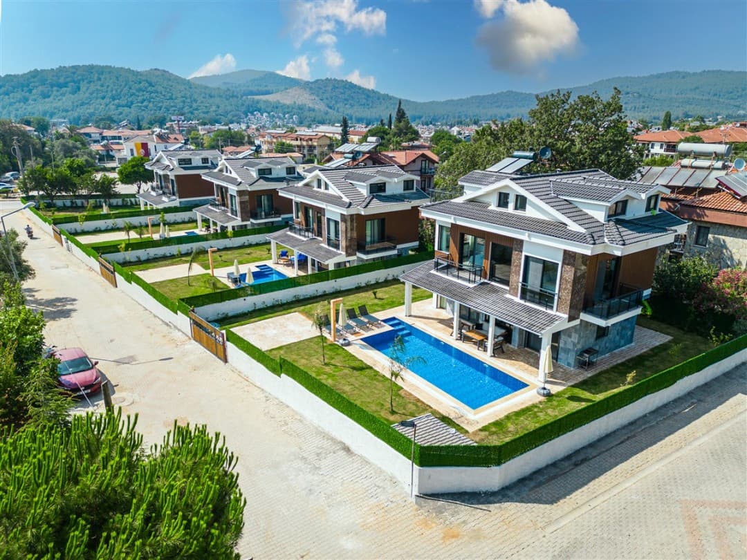 Havuzlu ve bahçeli lüks villaların havaadan çekilmiş genel görünümü.