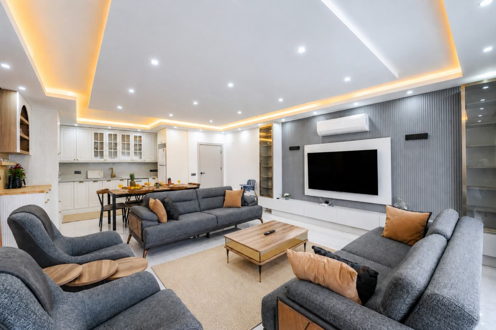Gri koltuk takımı, ahşap sehpası ve TV ünitesi bulunan aydınlık salon.