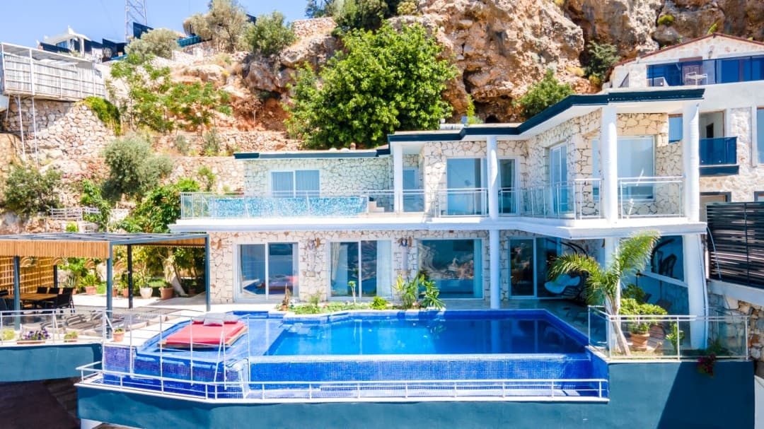 Taş duvarlı, havuzlu ve dağ yamacına kurulu iki katlı lüks villa.