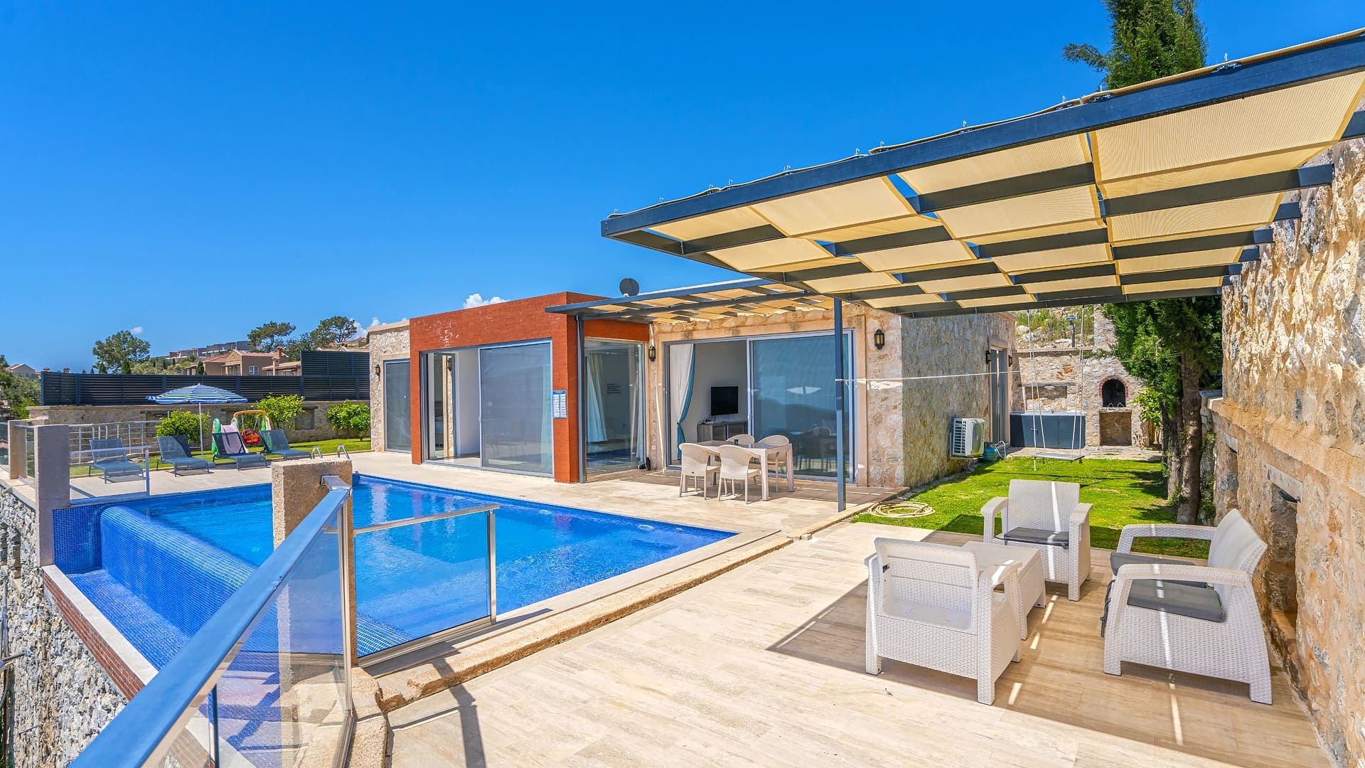 Güneş tenteli terası ve yüzme havuzu bulunan taş villa