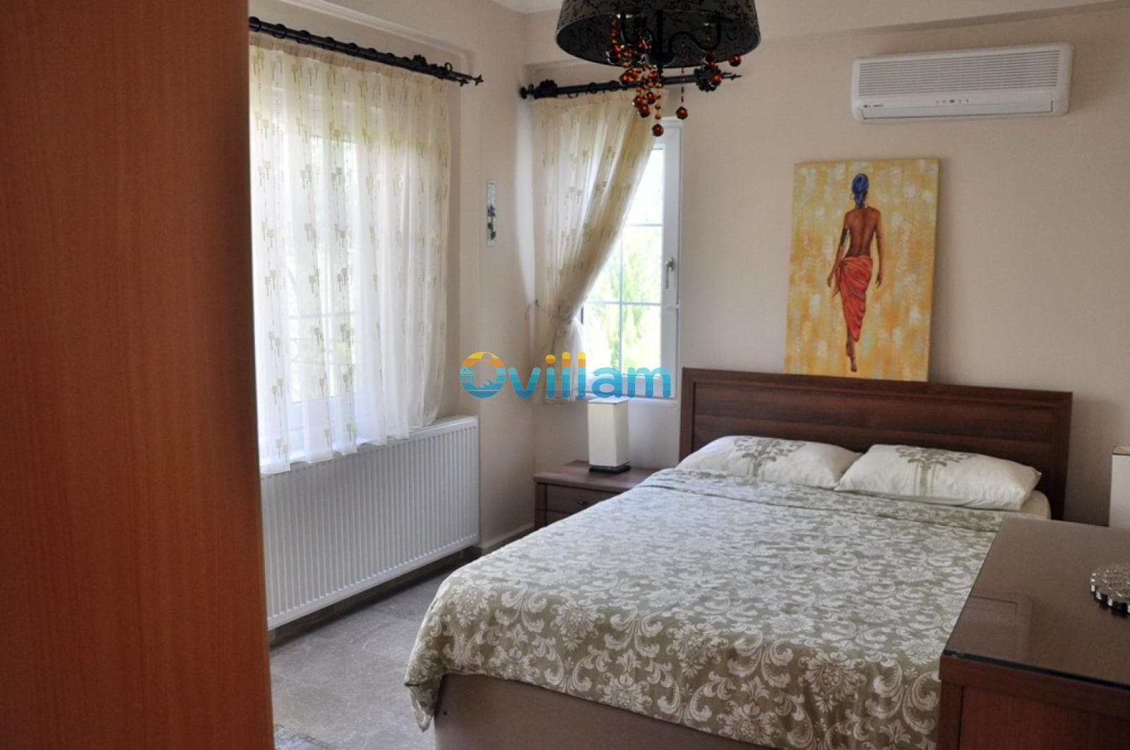 Ahşap yataklı ve tablolu aydınlık yatak odası