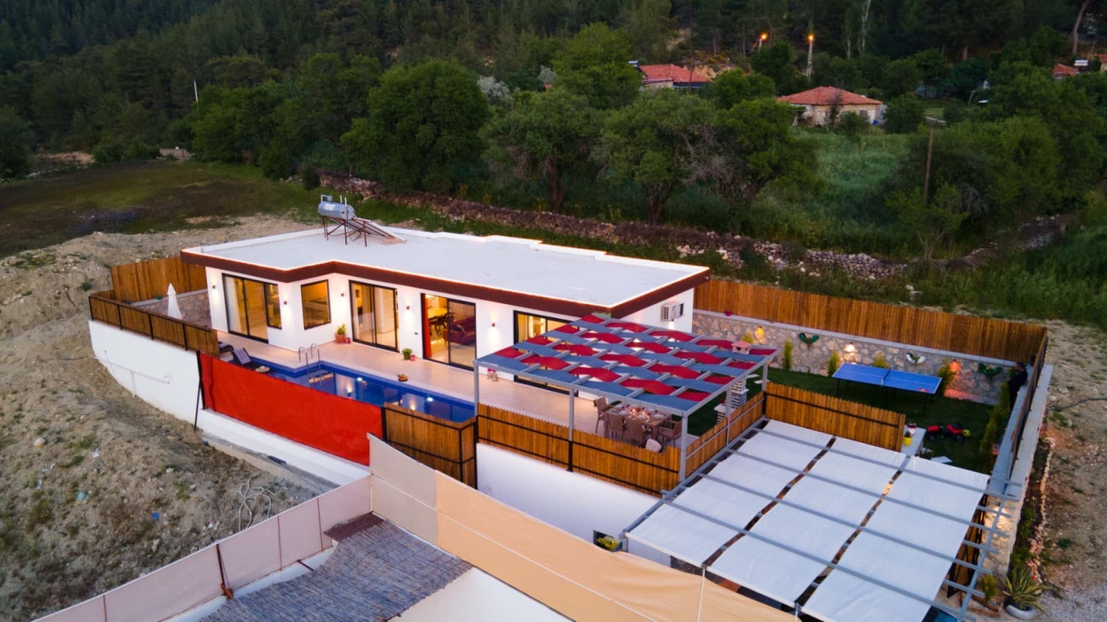 Havuzlu ve verandalı tek katlı villanın havadan çekilmiş genel görünümü.