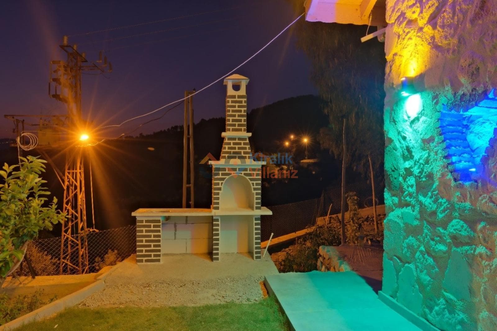 Açık havada konumlanmış tuğla detaylı taş barbekü alanı.