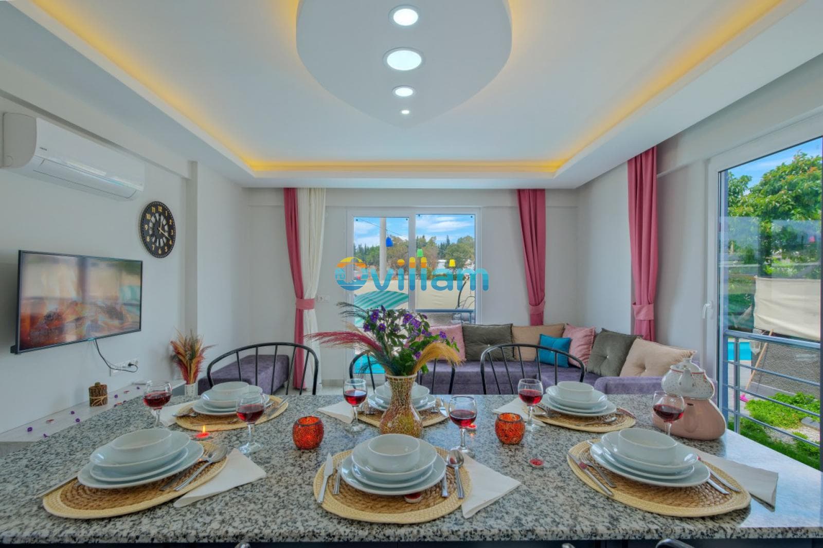 Ön planda şık bir yemek masası, arka planda ise oturma grubu olan aydınlık salon.
