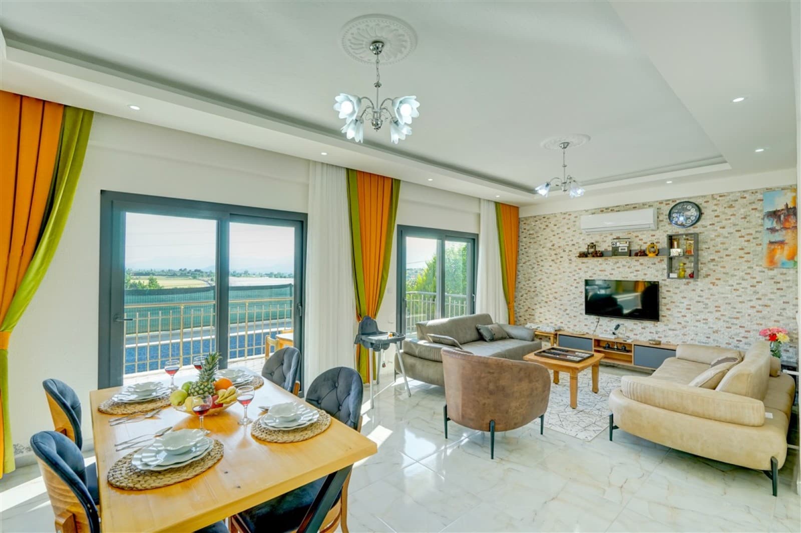 Yemek masası ve oturma grubu bulunan aydınlık salon.