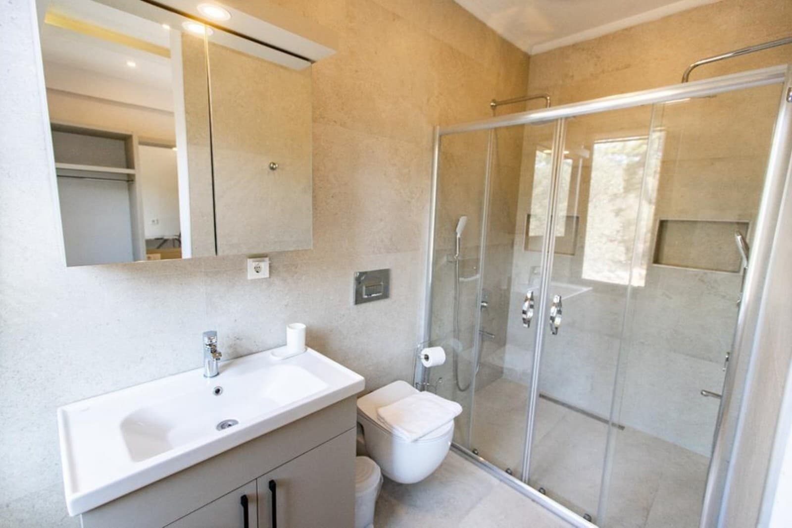Duşakabin, lavabo ve tuvaletin yer aldığı modern banyo.