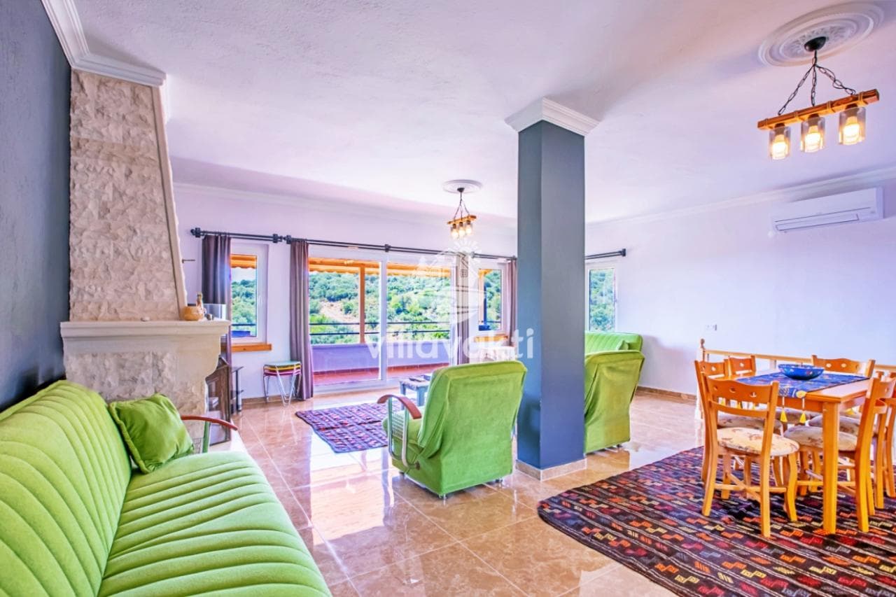 Yeşil tonlarında oturma grubu ve taş şömineli salon.