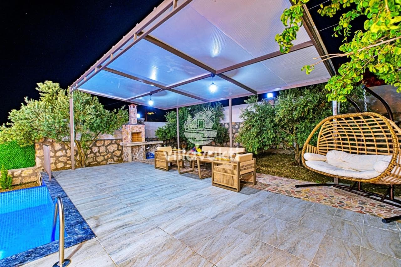 Havuz kenarında kamelya altında oturma grubu, salıncak ve taş barbekü alanı.