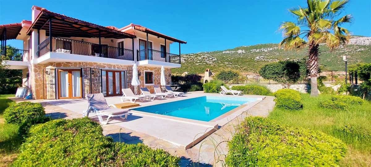 Geniş bahçesi, havuzu ve palmiye ağacı olan iki katlı müstakil villa.