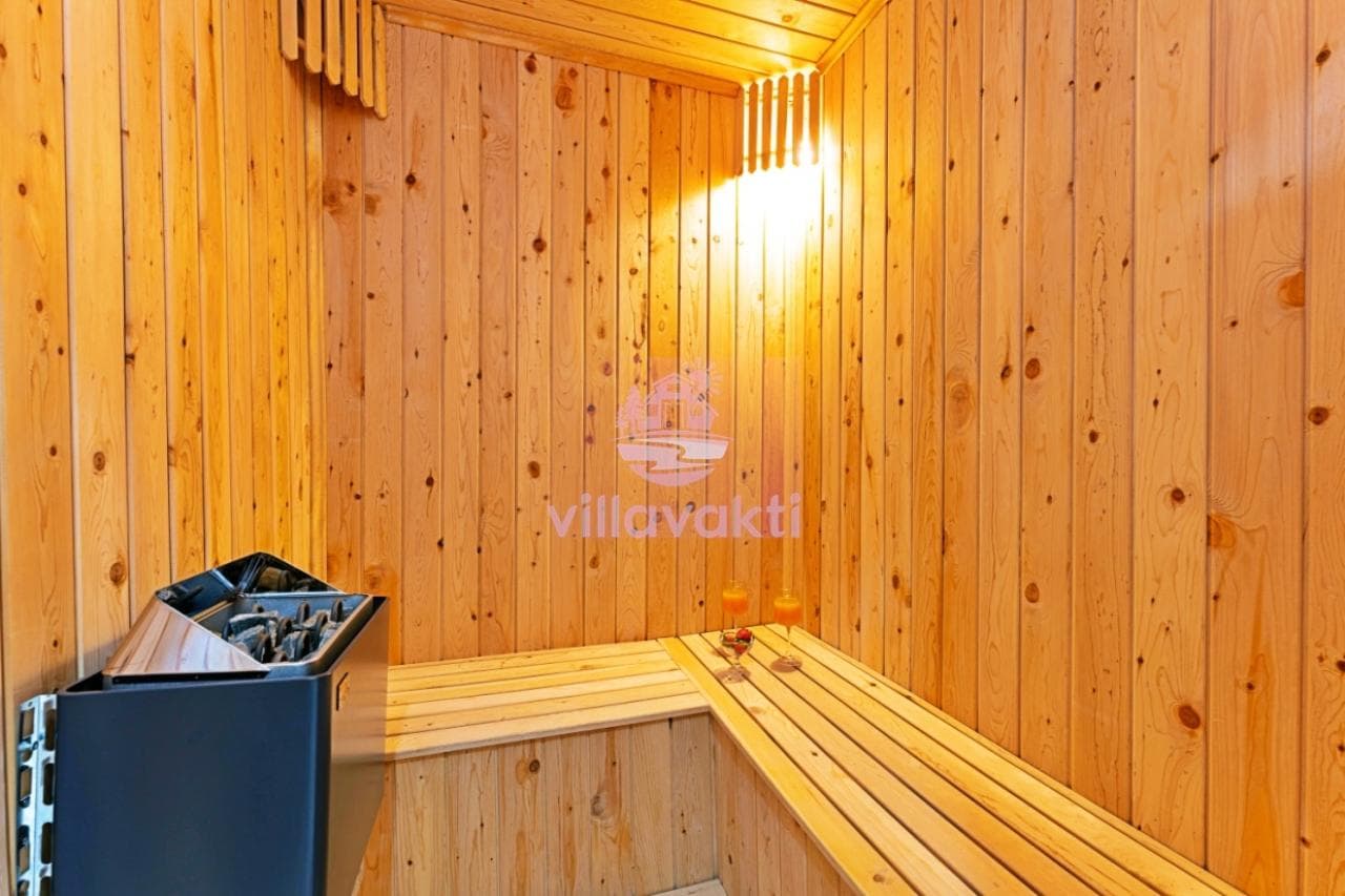 Ahşap kaplamalı duvarları ve oturma sedirleri olan sauna.