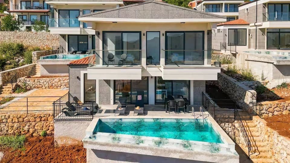 Katlı ve havuzlu modern mimariye sahip villanın dış cepheden görünümü.