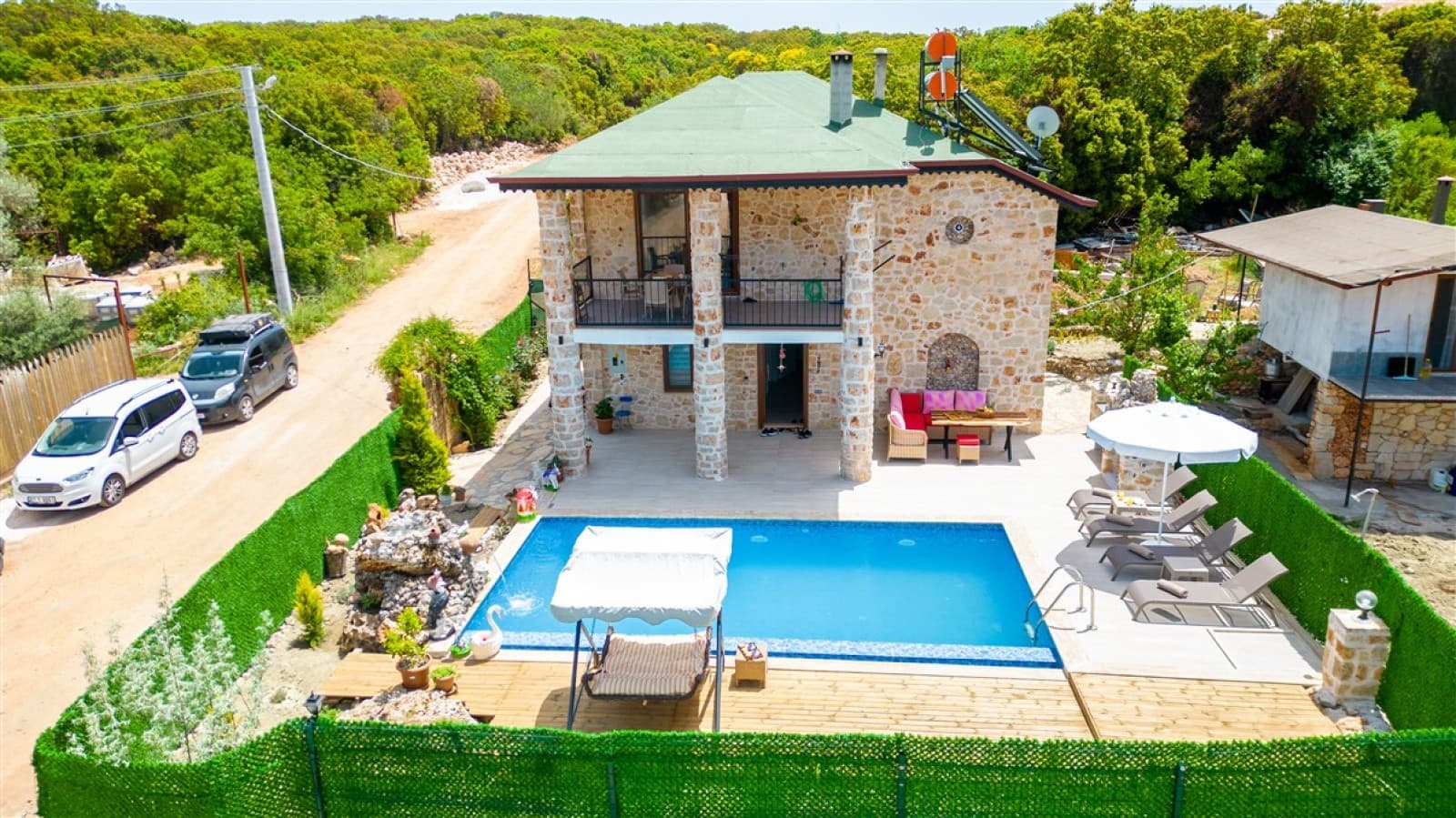 Doğa içinde, taş cepheli, havuzlu ve şezlonglu iki katlı müstakil villa.