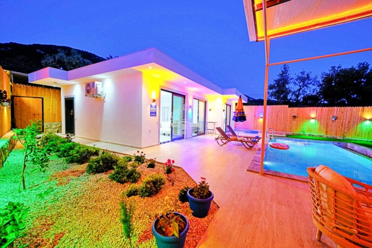 Akşam vakti havuzlu ve bahçeli tek katlı beyaz villa