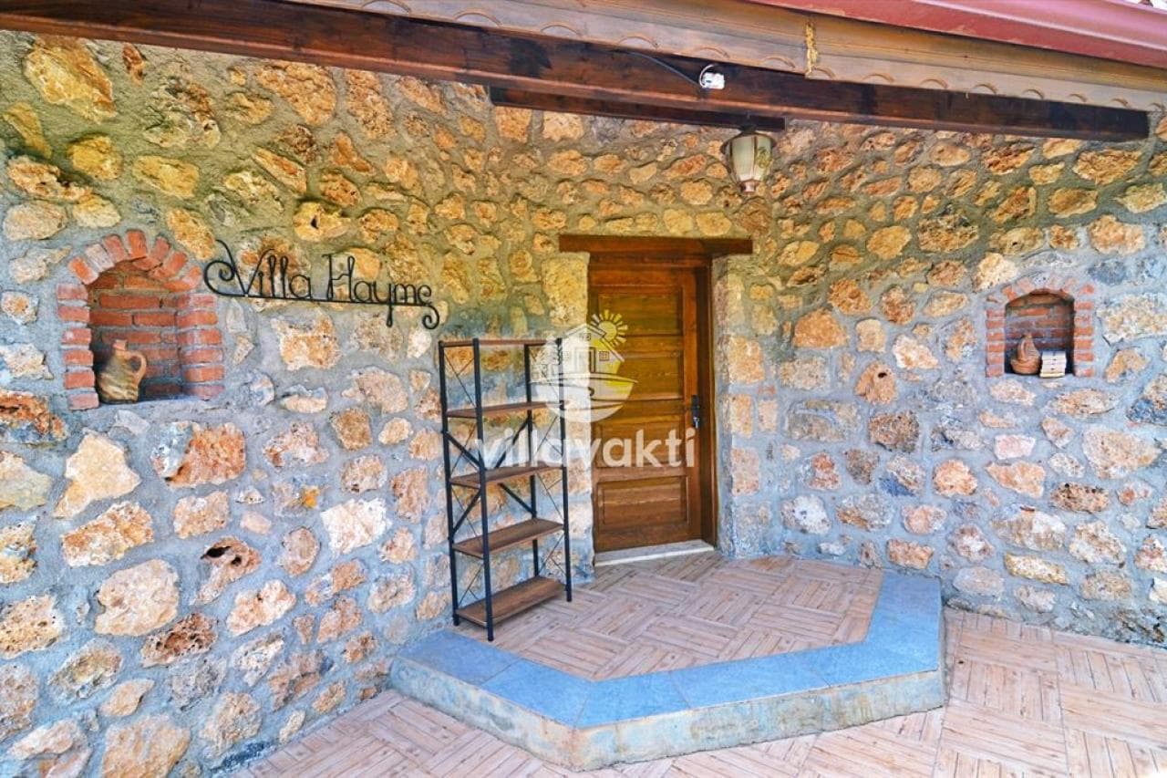 Villa Hayme yazılı taş duvarlı ve ahşap kapılı giriş cephesi.