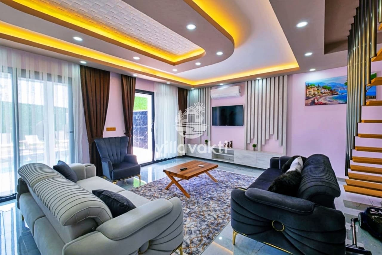 Gri koltuklar, ahşap sehpa ve TV ünitesi bulunan modern oturma odası.