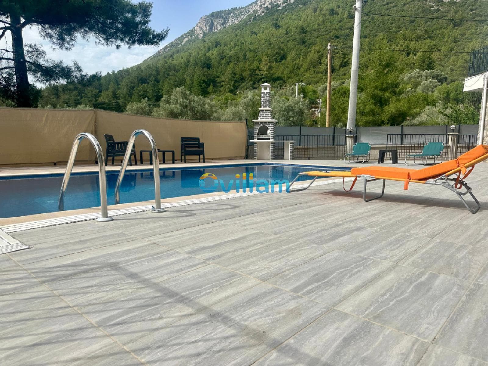 Orman manzaralı yüzme havuzu ve şezlonglar