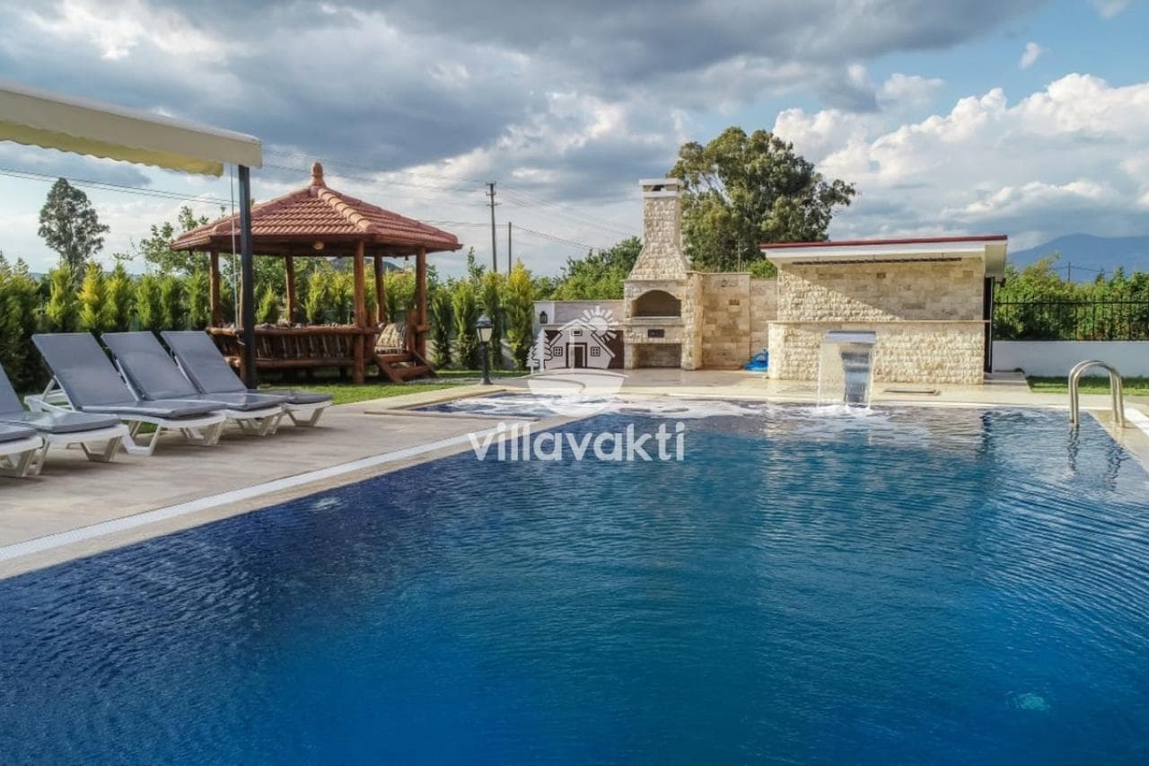 Taş barbekü alanı ve kameriyenin bulunduğu açık havuz.