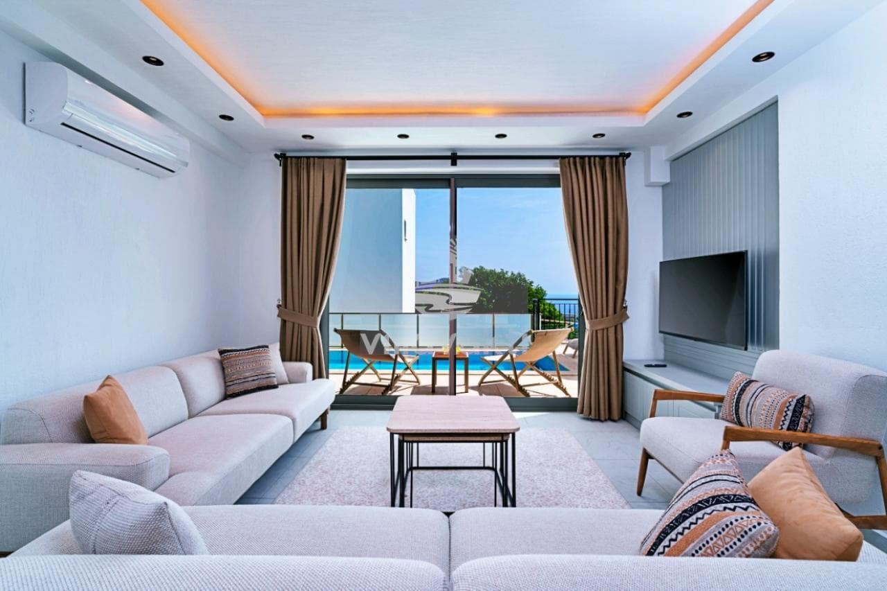 Beyaz koltuklar, sehpa ve havuz manzaralı geniş cam çıkışlı modern oturma odası.