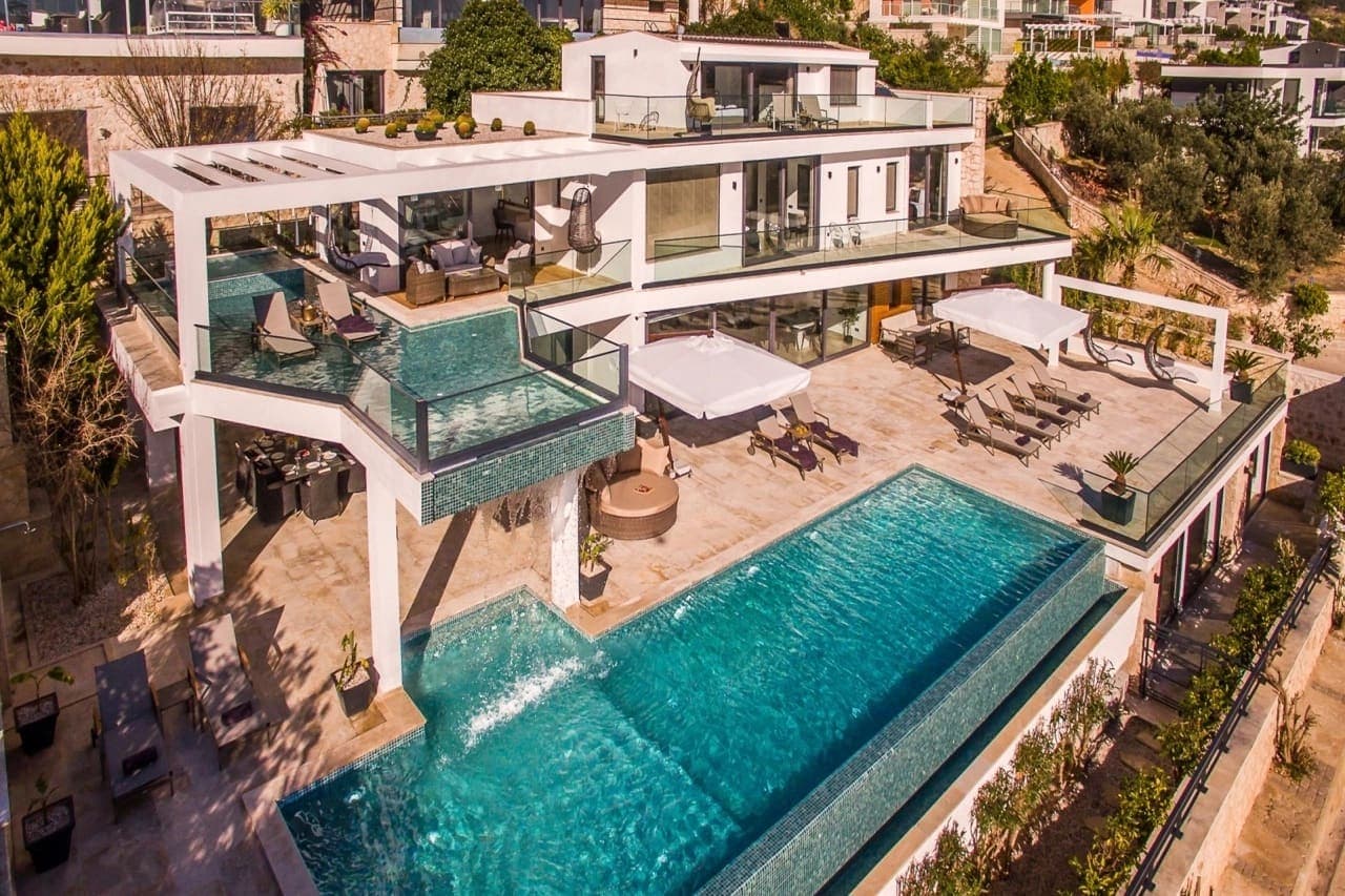 Geniş teraslı ve havuzlu modern mimariye sahip villa dış cephesi.