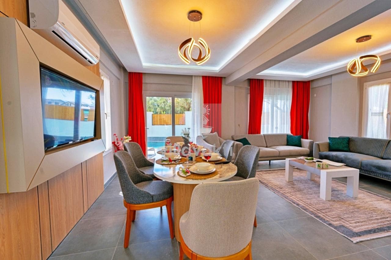 Modern tasarımlı salon, gri oturma grubu ve ortasında yemek masası bulunan iç mekân.