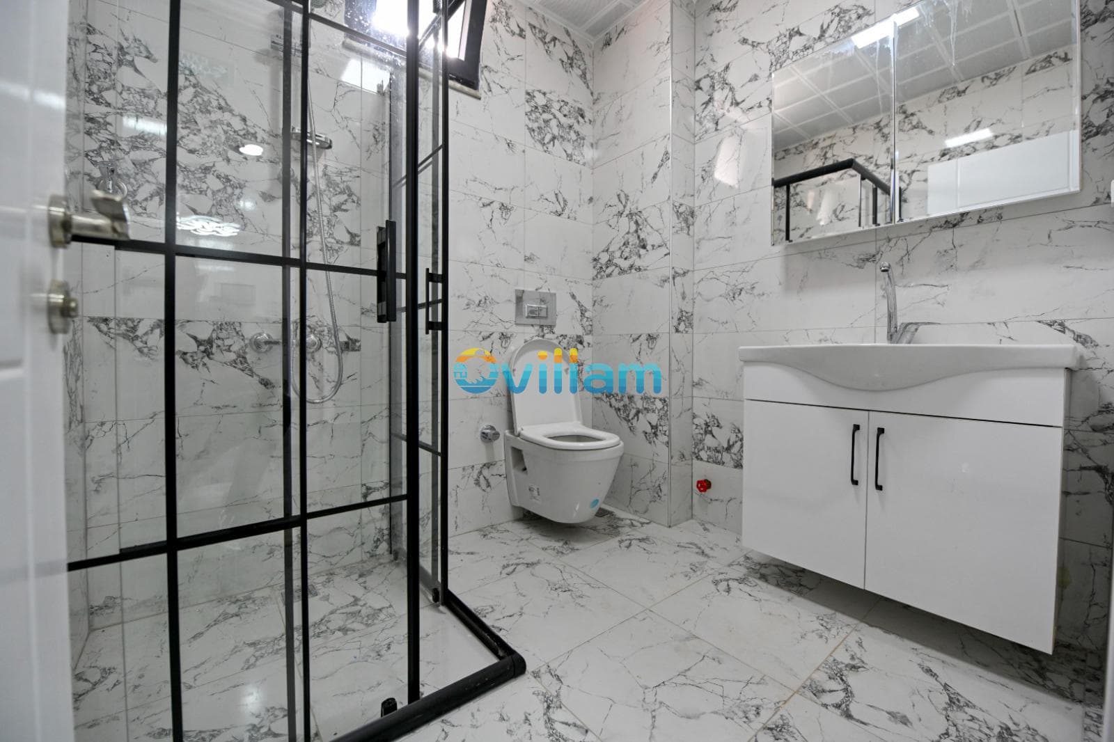 Mermer detaylı duşakabin, klozet ve lavabo bulunan modern banyo