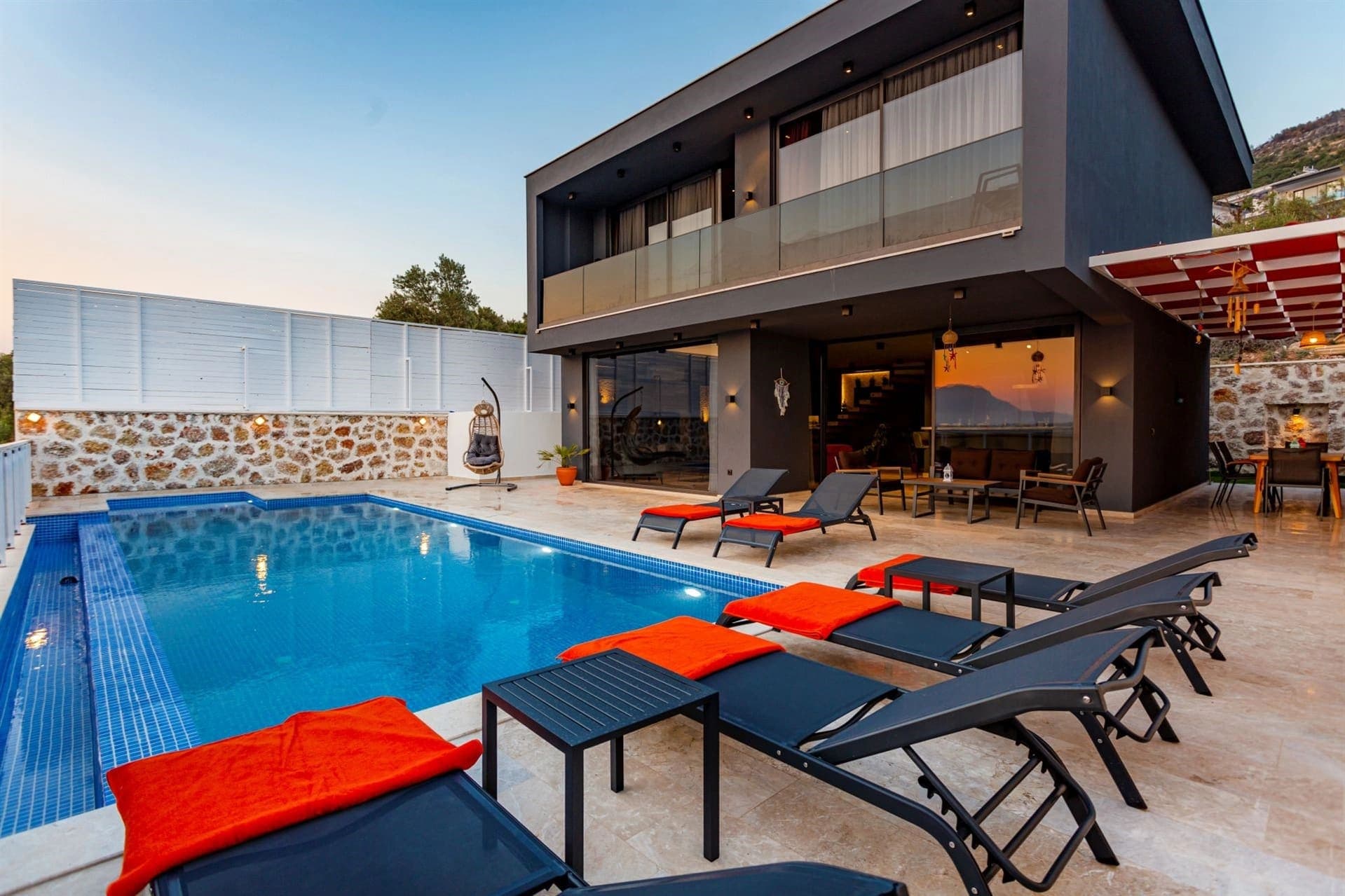 Havuz kenarında şezlonglar ve arka planda modern dış cephe