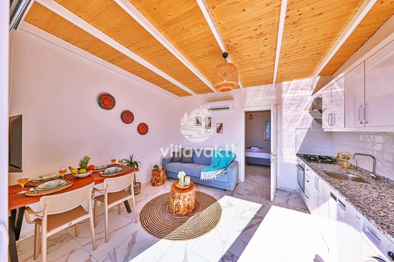 Ahşap tavanlı, mutfak ve oturma alanı bir arada olan modern iç mekan.