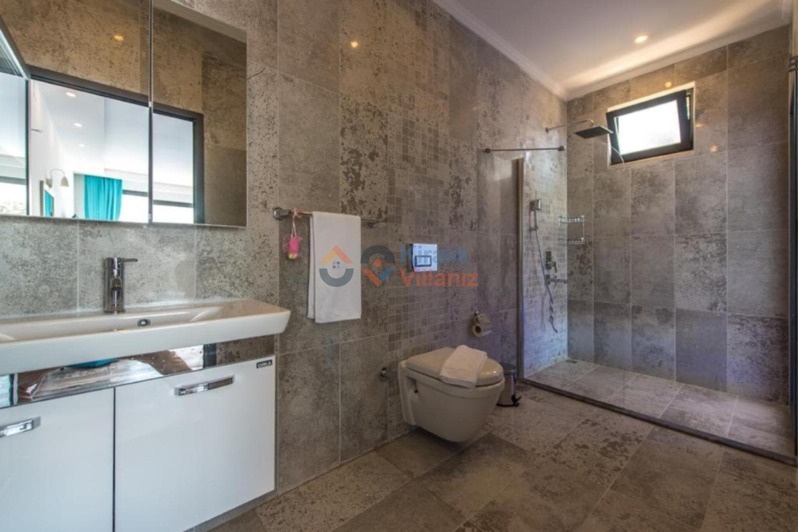 Gri seramik kaplı modern banyo, duş alanı ve lavabo.