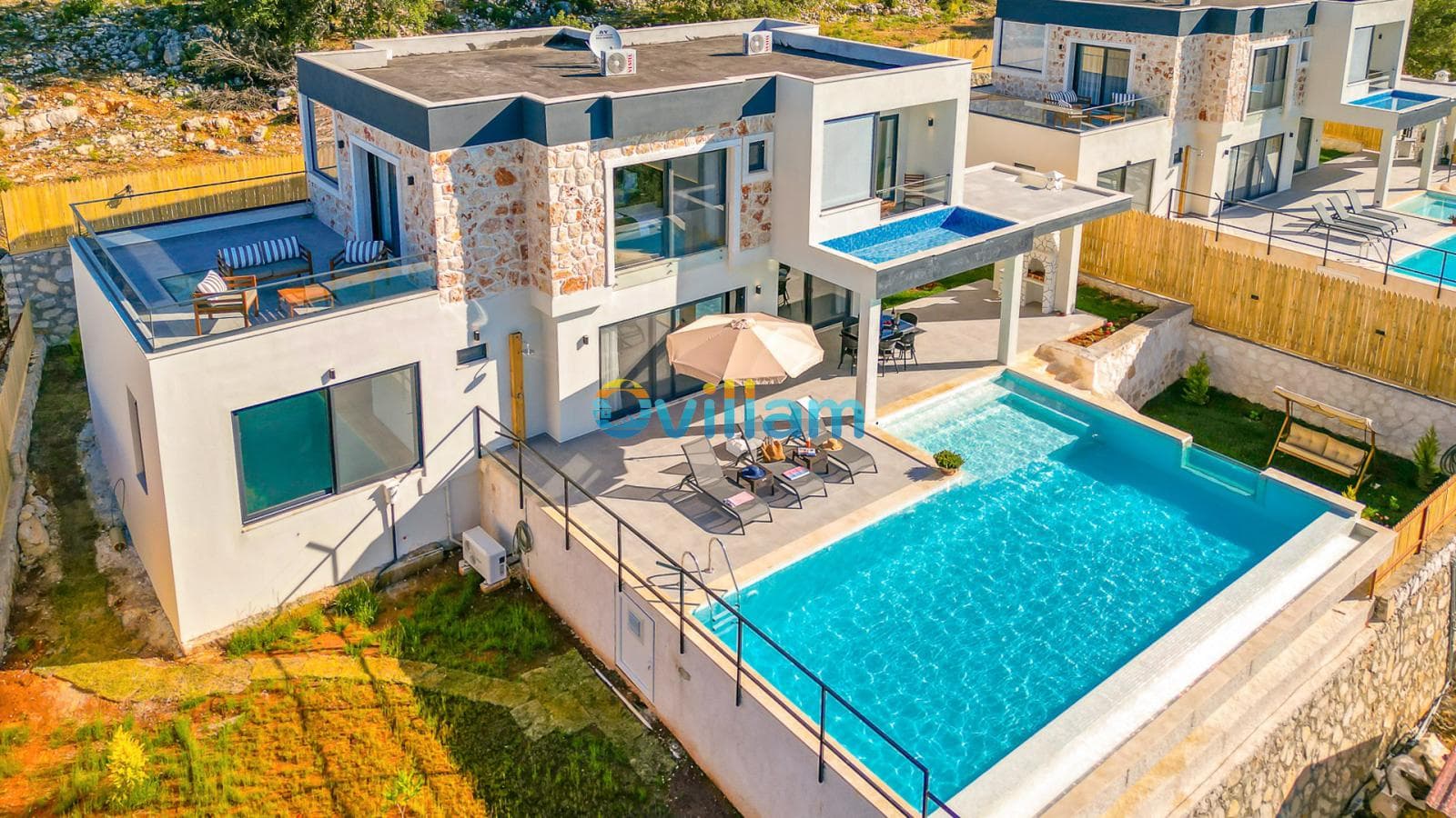 Havuzlu, teraslı ve taş detaylı modern dış cepheye sahip villa.