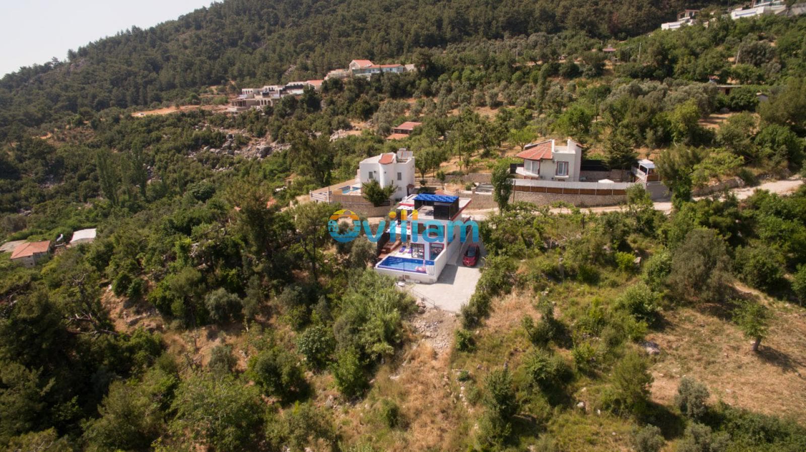 Ormanlık alanda yer alan villanın havadan geniş açılı görünümü.