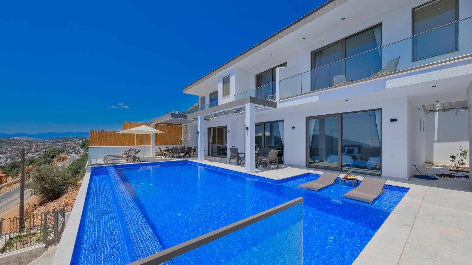 İki katlı modern villanın havuzlu dış cephesi.