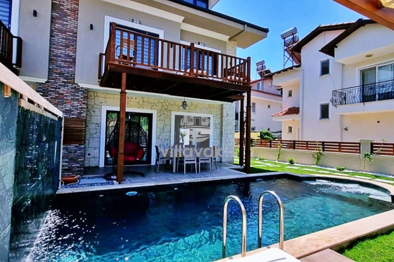 Müstakil villanın havuzu, taş duvarlı dış cephesi ve ahşap balkon detayları.