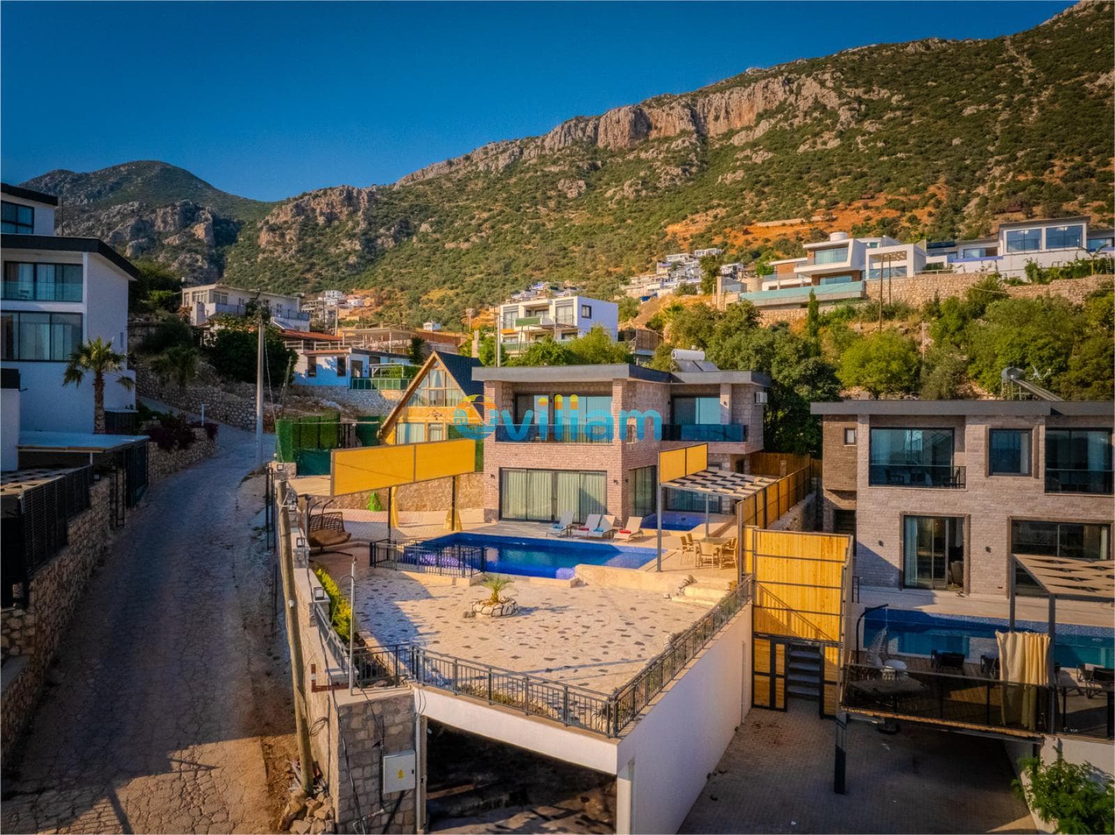 Dağ yamacında, havuzlu ve teraslı modern taş villa.