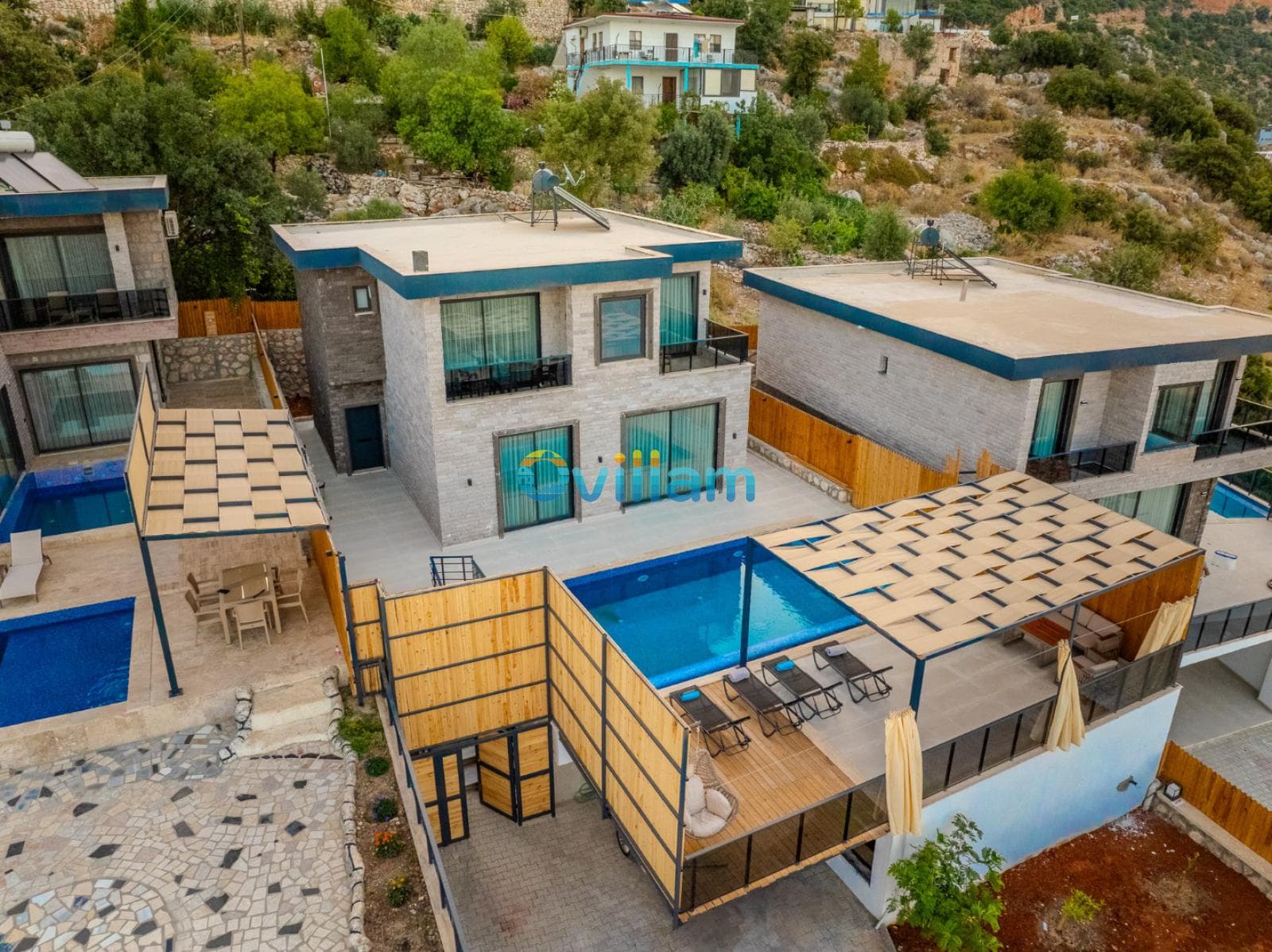 Havuzlu ve şezlonglu terası bulunan iki katlı taş villa.